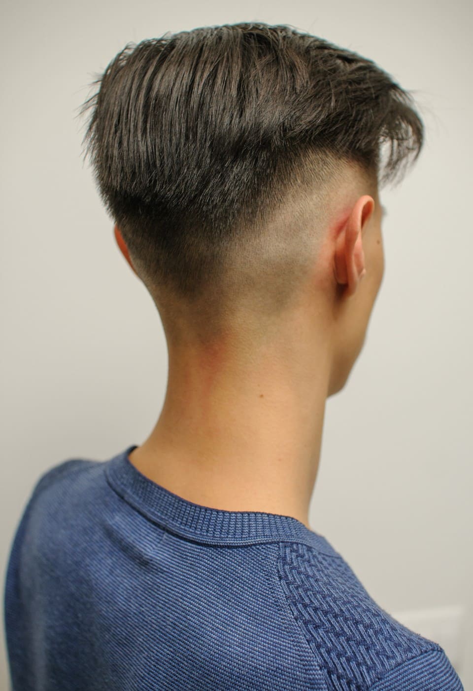 Herrenfrisur mit Undercut und brünetten Haaren, Ansicht von hinten
